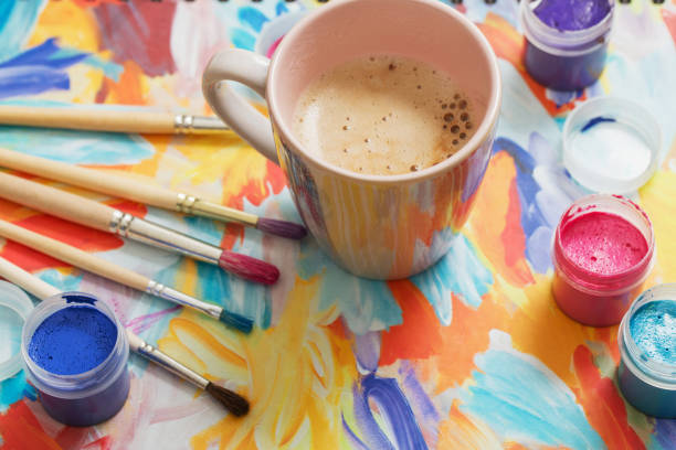 paints, brushes and cup of coffee on paper