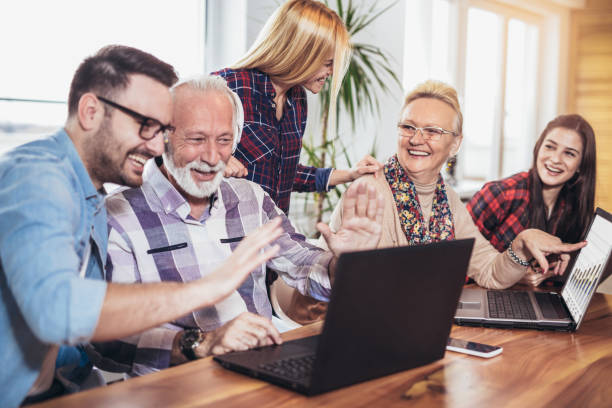 istock Young volunteers help senior people on the computer 956153218
