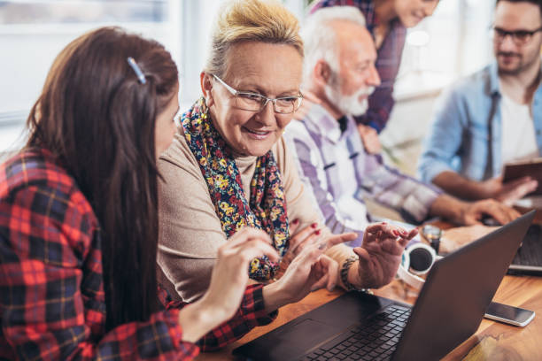 istock Young volunteers help senior people on the computer 956153720