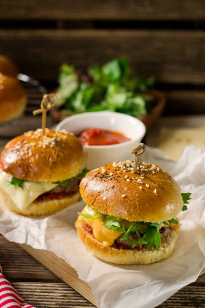 istock Mini cheeseburgers sliders with ground beef, cheddar, lettuce and tomato sauce 956157394