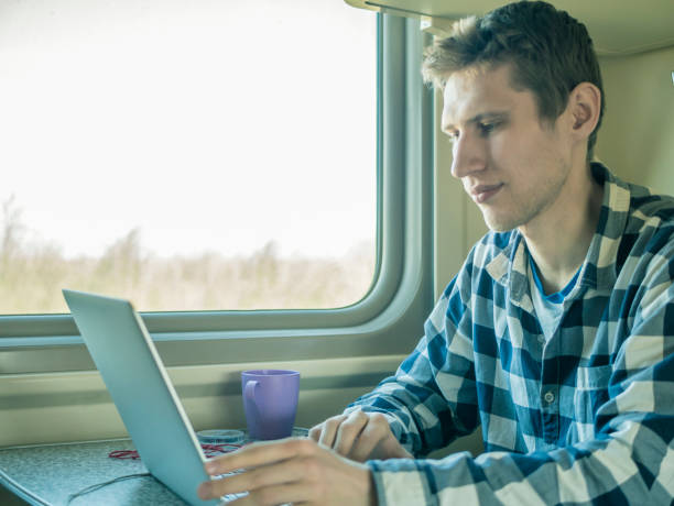 istock young man sitting near the window at the table while journey by train 956157970