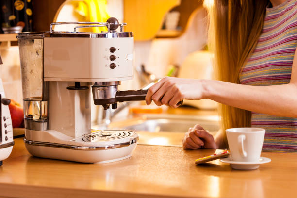 istock Woman in kitchen making coffee from machine 956160496