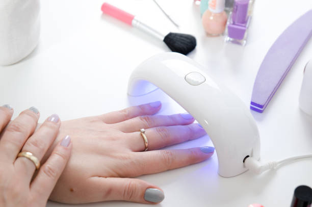 istock Woman using UV light dryer. Manicure, spa salon concept. 956160940