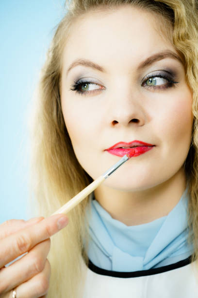 istock Applying lipstick on fashion model lips 956161892