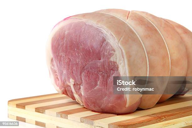 A Tied Up Piece Of Pork On A Striped Chopping Board Stock Photo - Download Image Now