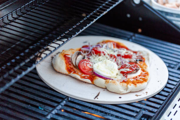 Cooking pizza on outdoor gas grill.