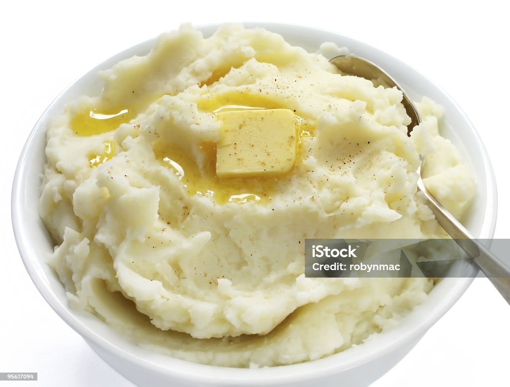 A bowl of finely mashed potato with butter on top Bowl of mashed potato with melting butter and a sprinkle of nutmeg.  More fruits and vegetables: Mashed Potatoes Stock Photo