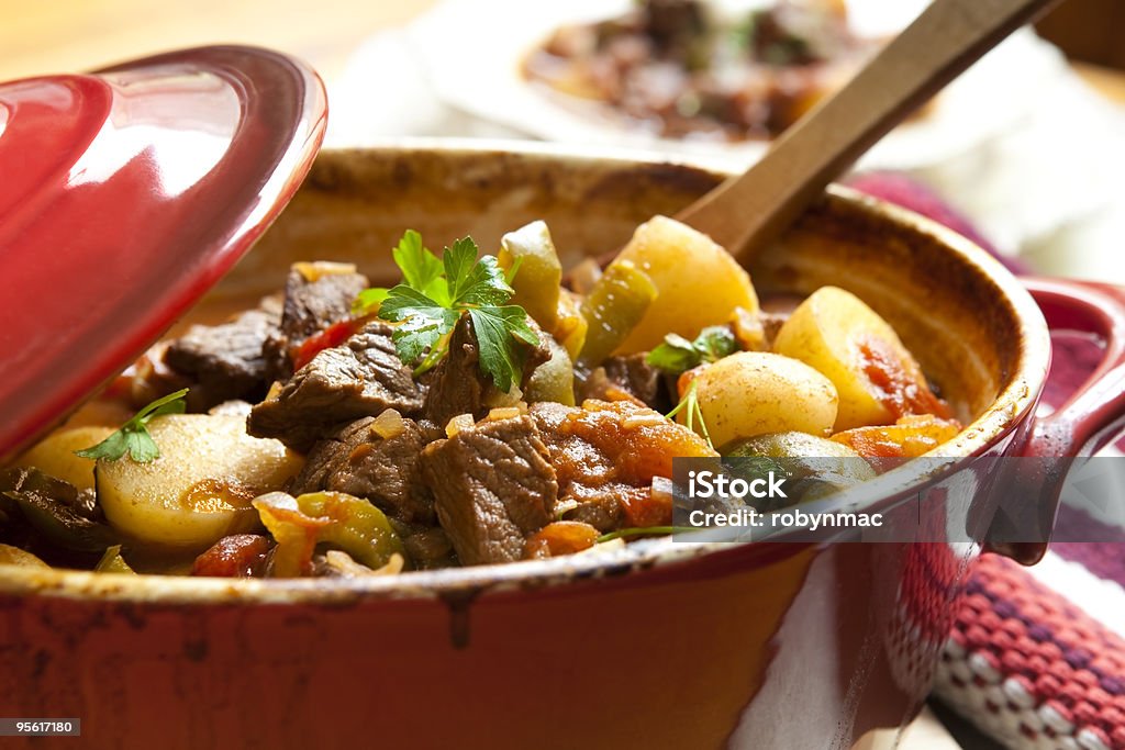 Beef Stew Traditional goulash or beef stew, in red crock pot, ready to serve.  Shallow DOF.  More beef images: Stew Stock Photo