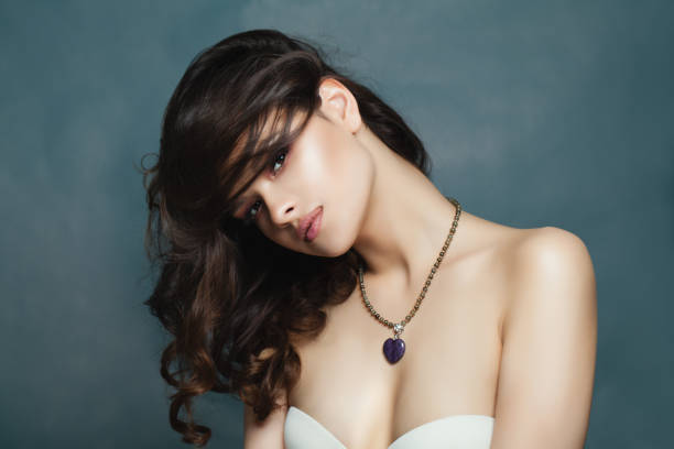 sexy brünette modell mit dunklem welliges haar und edelstein halskette - jewelry fashion model women gem stock-fotos und bilder