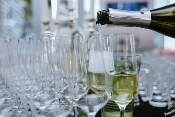 istock Pouring sparkling wine from bottle into the champagne glass 956175620