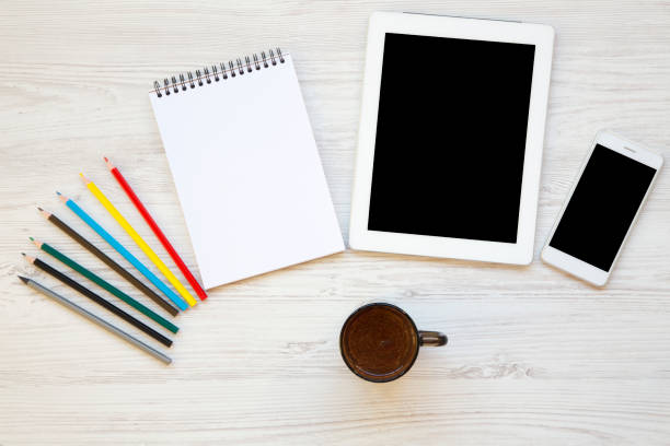 istock Feminine workspace with tablet, smartphone, notebook, color pencils and latte. Top view. 956176396