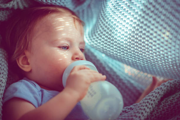 Cute baby boy drinking milk in the morning