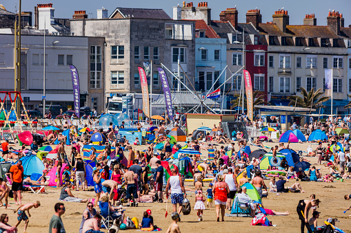 7th. May 2018 This is Weymouth Beach Dorset England UK. It is early spring bank holiday on a record breaking day for temperatures. There are thousands of people on the crowded beach sunbathing having fun on the sand or in the sea.