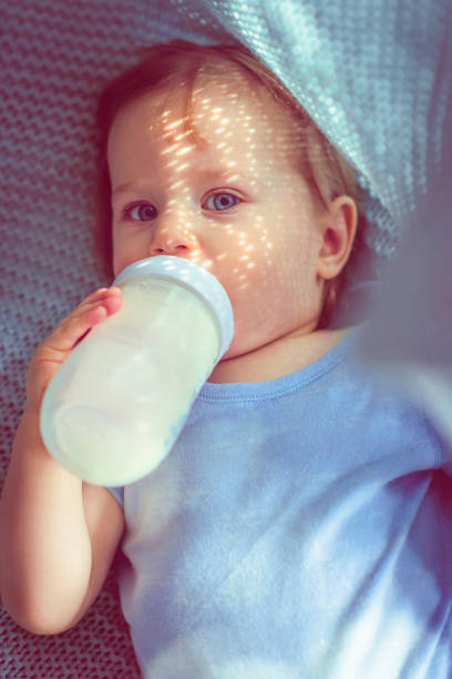 Cute baby boy drinking milk in the morning