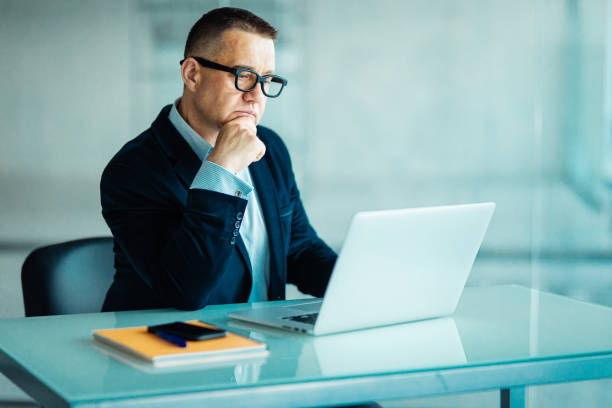 istock Senior man in modern office working on laptop computer 956180064