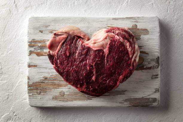 bistecca di ribeye marmorizzazione su piatto di legno - meat beef love heart shape foto e immagini stock