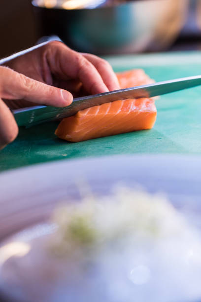 istock japanese chef cutting up salmon on a green table. sushi concept 956192054