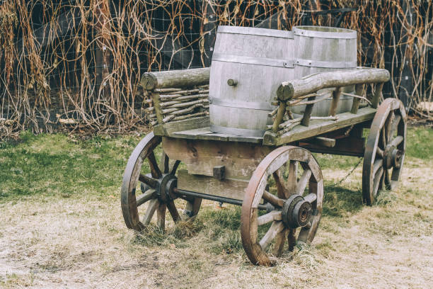 istock Antique cart with three barrels for transporting goods toned 956192768
