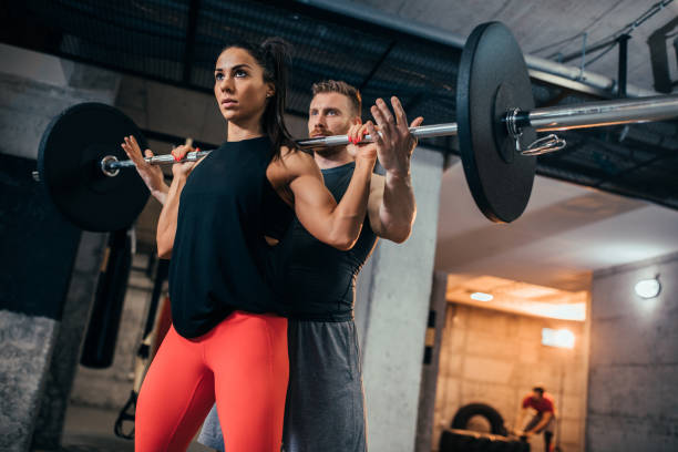 levante a barra superior - crouching exercising women barbell - fotografias e filmes do acervo