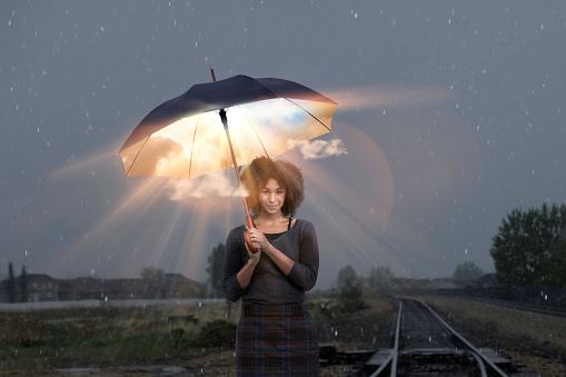 Woman with umbrella in rain with sun and clouds inside showing her sunny disposition.