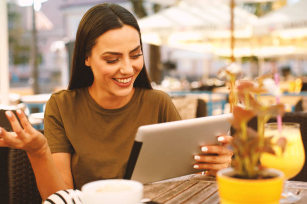 istock Young woman using a digital tablet in a cafe 956199884