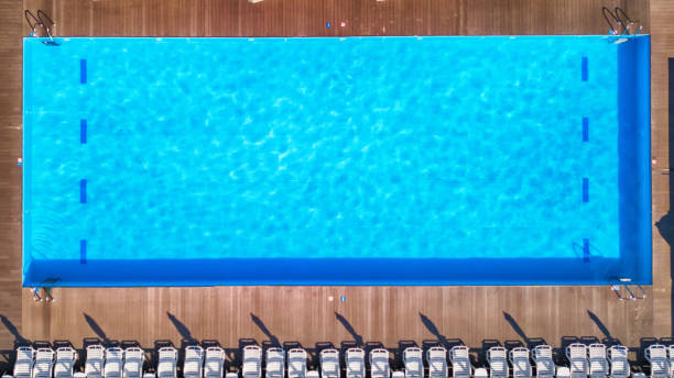 istock blue swimming pool summer vacation with white sun beds, top view 956205282