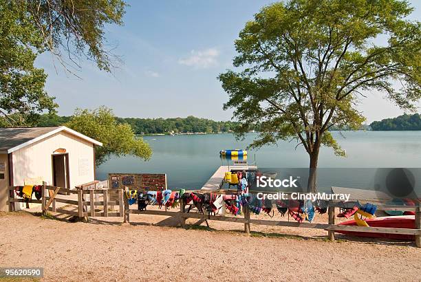 Summer Camp Lake With Life Jackets Hanging On Fence Stock Photo - Download Image Now