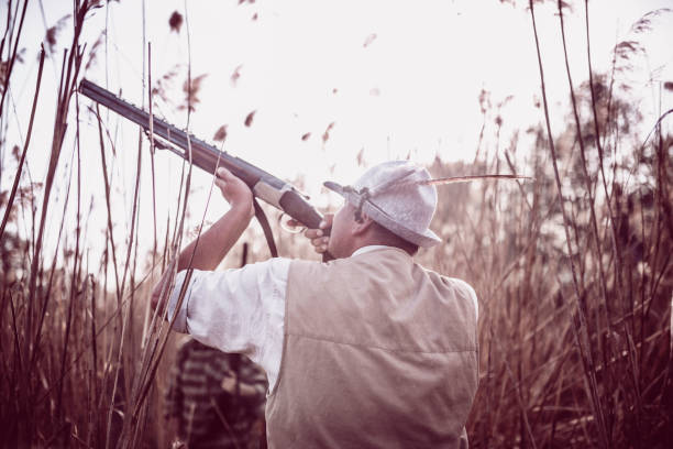 grupa myśliwych ukrytych na bagnach i przygotowujących się do polowania - hunting two people camouflage rifle zdjęcia i obrazy z banku zdjęć