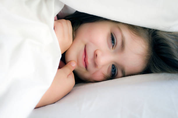istock Smiling little girl in the bed 956218176