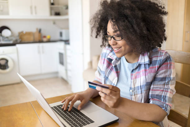 istock Woman with eyeglasses using laptop and credit card 956218260