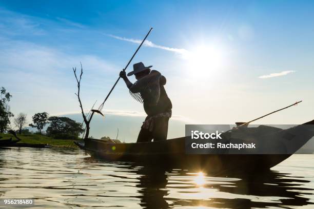 Silhouette Of Fishermen Using Cooplike Trap Catching Fish In Lake With Beautiful Scenery Of Nature Morning Sunrise Beautiful Scenery At Bangpra Chonburi Province Thailand Stock Photo - Download Image Now