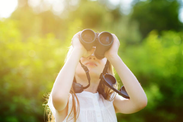 istock Funny little girl looking through binoculars 956221706