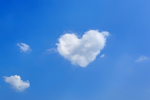 background from the blue sky with a white cloud in the form of heart.