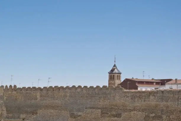 Ancient stonewalls surrounding the town of Mansilla de las Mulas (Leon, Spain), and tower church of Santa Maria, on the Way of St James (Camino de Santiago), to Compostela