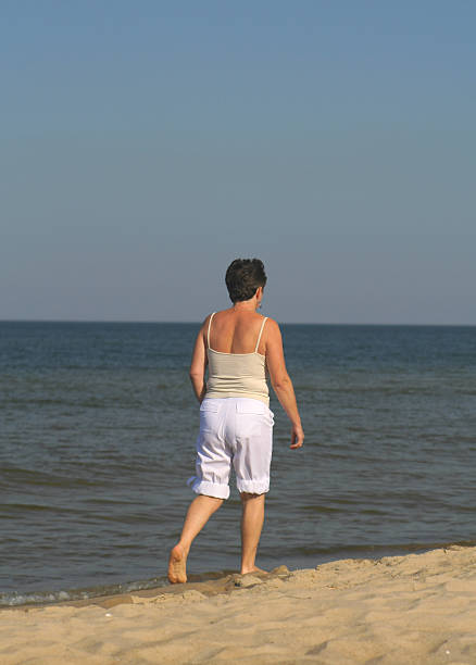 istock woman walking on the beach 95622788