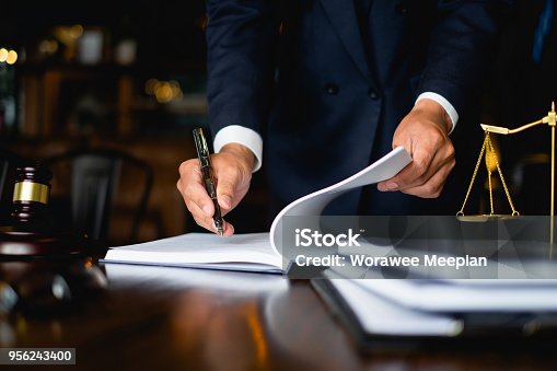 istock Close up lawyer businessman working or reading lawbook in office workplace for consultant lawyer concept. 956243400