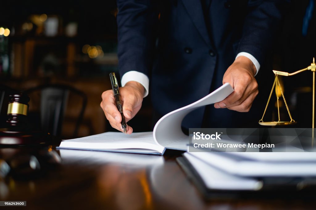 Close up lawyer businessman working or reading lawbook in office workplace for consultant lawyer concept. Law Stock Photo