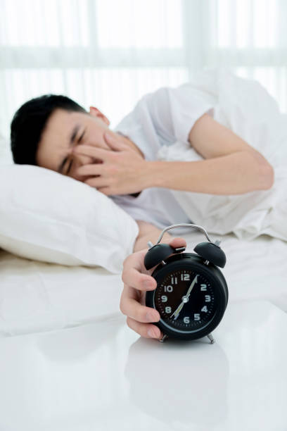 istock Man reaching to turning off alarm clock 956243694