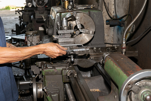 Hands of engineer. He hold vernier caliper being check the quality of the parts at lathe