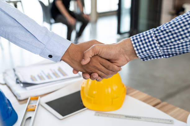 istock Engineering and businessman shaking hands after successful deal while working in the office center 956247418