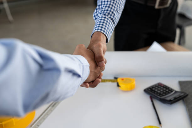 istock Engineering and businessman shaking hands after successful deal while working in the office center 956247464