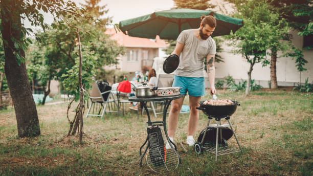 istock Young man grilling meat in the backyard on a sunny day 956248042