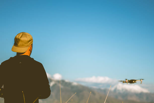 istock Young Man flying a drone at dusk with mountains in the background 956250156
