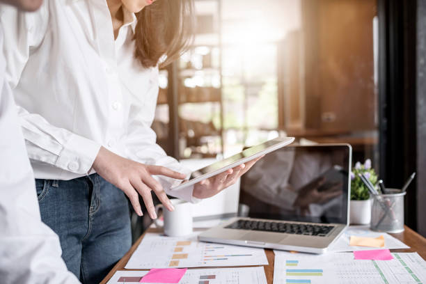 istock Businesswoman using tablet while standing at desk in modern office 956250472