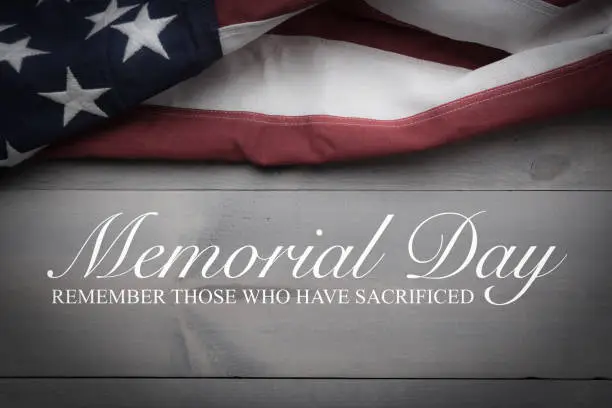 The flag of the United Sates of America on a grey plank background with memorial day