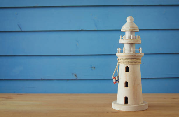 vacation and summer image with lighthouse over blue wooden planks background