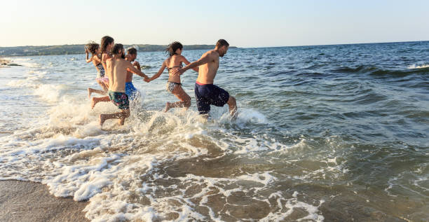 istock Friends jumping in the sea 956265178