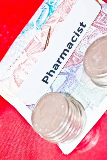 istock Coins, Euro Note and Pharmacist Badge On Red Surface 956266488