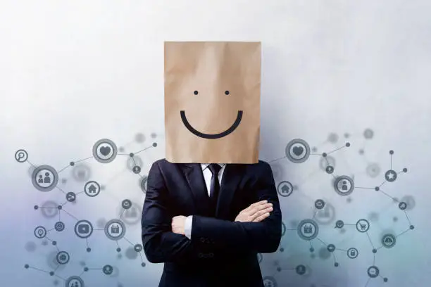 Photo of Customer Experience Concept, Portrait of Happy Businessman Client with Smiley Face Emotion on Paper Bag, Crossed arms and wearing Suit, Standing at the Wall with Social Network Icons
