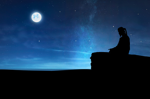 Silhouette of muslim man praying at night